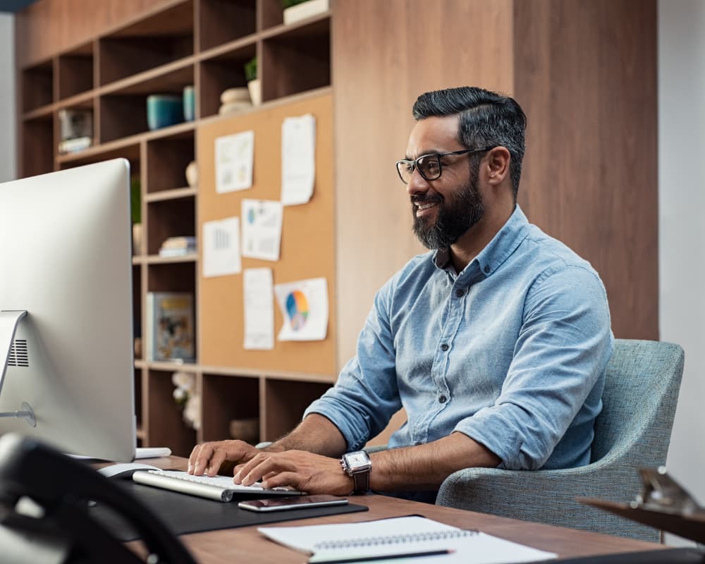 Small business owner using digital tools at a desk to manage finances and improve cash flow efficiency