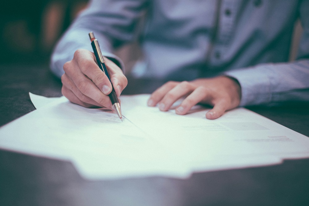 Business owner signing a debt relief agreement to resolve MCA repayments