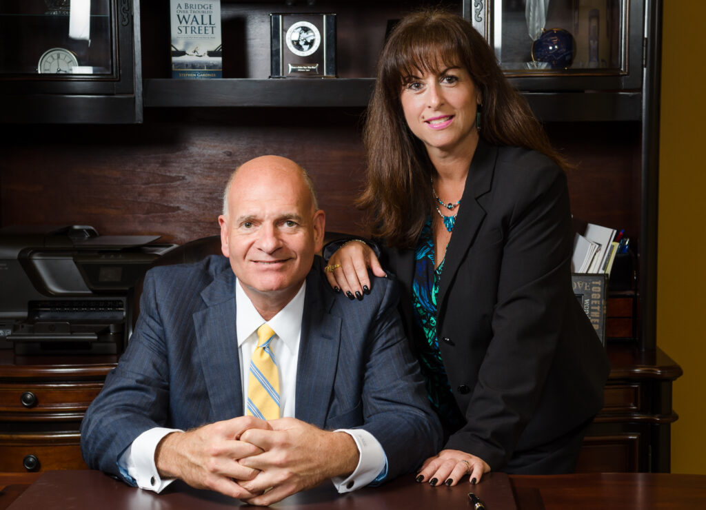 Male and female business leaders at Value Capital Funding posing in a wood-panelled office